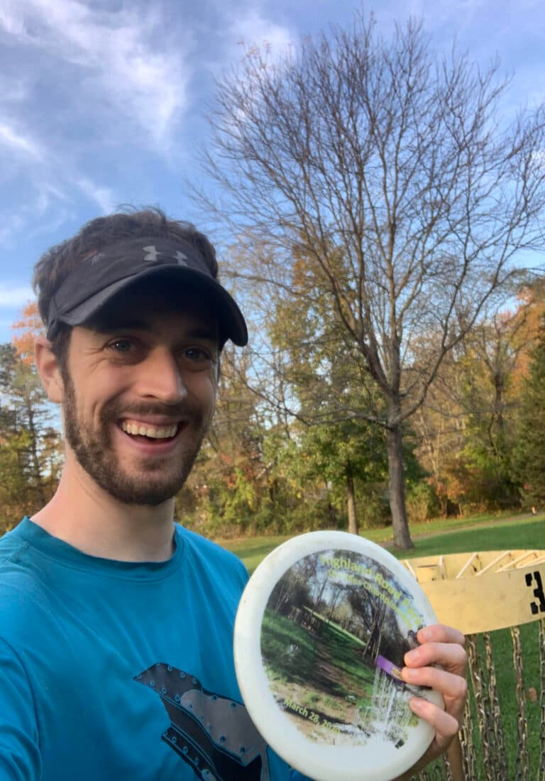 Sam Goldsmith holding a disc on a disc golf course
